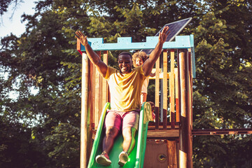 African American dad on toboggan with daughter.