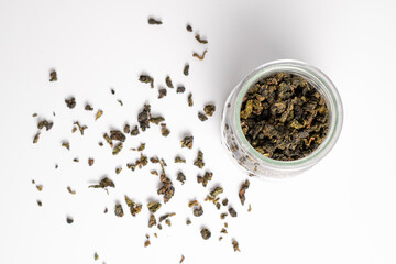 Green fermented tea in a small glass jar. Imperial Milk oolong tea isolated on white background. Chinese milk oolong tea