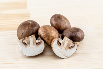 royal big brown champignons whole and half on a wooden background