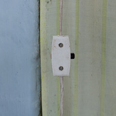 Vintage white light switch with black button. Retro switch scenery.