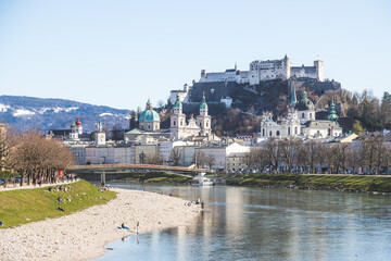 Fototapeta na wymiar Salzburg spring time: Panoramic city landscape with Salzach with green grass and historic district