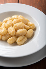 Piatto di deliziosi gnocchi di patate con burro e formaggio, Cucina Italiana 