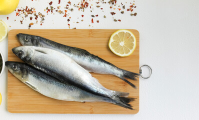 Fish herring with lemon on a wooden chopping board.