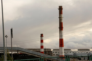 Industrial complex. Striped pipes, emissions, environmental conditions.