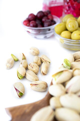 Appetizer time. Coconut wood tray with pistachios. Nuts and olives, healthy snacks. Mediterranean diet. Food photography