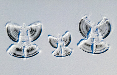 Mutter, Vater und Kind als Schneeengel