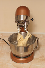 Kneading the dough in an electric mixer. Making dough at home for baking in a mixer