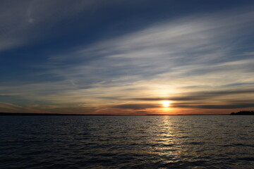 Sunset in the clouds  over the lake blue water