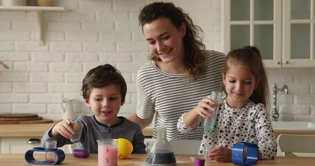 Young mother and kids little scientists play chemistry kit in kitchen, family make funny scientific experiment, having fun together at home on weekend. Learning through play, hobby, education concept - Powered by Adobe