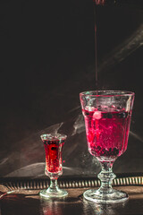 Berry drink. Dark photography. Front of the glass in focus.