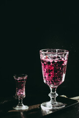 Berry drink. Dark photography. Front of the glass in focus.