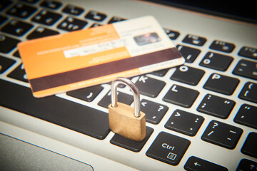 Padlock and credit cards on  computer keyboard. E-commerce data, eshopping and ebanking protection, internet and finance security concept. Selective focus to padlock
