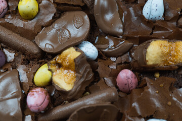 Home baking Easter concept. Brownie with chocolate bars, mini easter eggs and biscuits baked in. Chocolate feast home baked treat