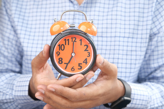  Man Hand Holding Alarm Clock Close Up 