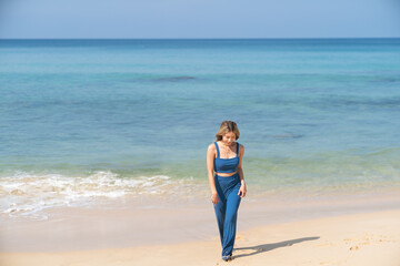 Fototapeta na wymiar Woman walking on the beach alone. Beach summer holiday vacation.