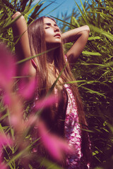 Sensual woman in pink petal dress with flower