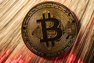 Gold Bitcoin coin with red backlight. Crypto currency. Bitcoin mining concept. Selective focus