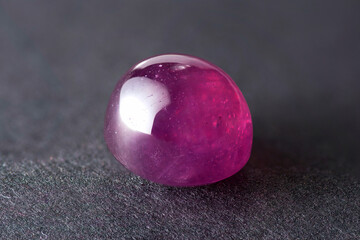 Natural heated, treated, lead glass filled, oval cabochon pale pink ruby (corundum) Madagascar. Details, micro cracks, bubbles, inclusions, glass flux flow. Close-up sharp details macro stack photo.