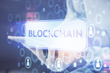Double exposure of man's hands holding and using a phone and crypto currency blockchain theme...