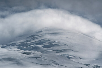 Clouds flowing through the summit of Elbrus. Prielbrusye National Park, Kabardino-Balkaria, Caucasus, Russia.