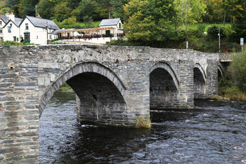 Fototapeta na wymiar An ancient bridge across the River Dee at Carrog, Wales, UK.