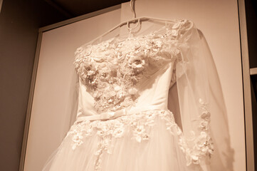 The wedding dress is hanging on a hanger