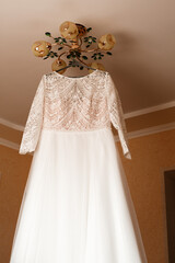 The wedding dress is hanging on a hanger