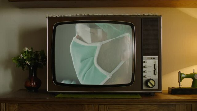 A retro analog TV showing a scientist or a doctor putting on a face mask.