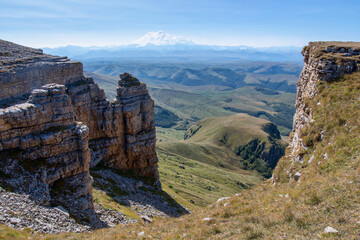 View of  Bermamyt plateau rocks and Mount Elbrus on sunny summer day. Karachay-Cherkessia, Caucasus, Russia.