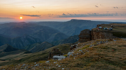 Sunset Caucasian landscape. View of camp on the cliff edge of Bermamyt plateau. Karachay-Cherkessia, Caucasus, Russia.