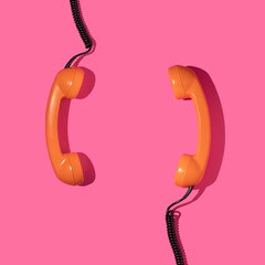 Creative layout with couple old phone handsets on bright pink background. Retro fashion style....