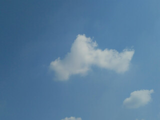 Flying fluffy Clouds on blue beautiful sky on a sunny day