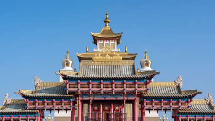 View of Golden Temple of Buddha Shakyamuni and the main gates against blue sky. Elista, Kalmykia, Russia. Inscription on the gates means &ldquo;Golden Temple of Buddha Shakyamuni&rdquo;.