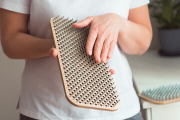 person hold in hands sadhu board - bed of nails, preparing for yoga practice. Mindfulness and alternative medicine concept.