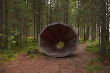Funny man made large wooden speaking tube in harmony with nature on hiking trail in forest (location Estonia).