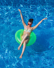 young pretty woman in swimwear has fun in swimming pool