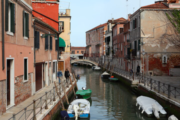 Fototapeta na wymiar Narrow canal between colorful historic buildings in Venice, Italy