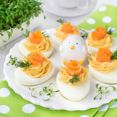 Eggs stuffed with smoked salmon paste, decorated with pieces of salmon and fresh dill.