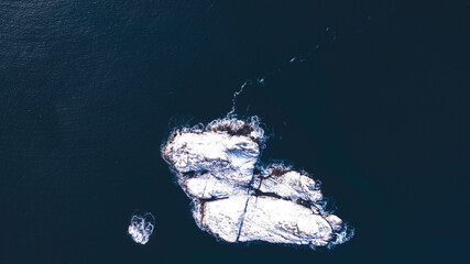 Breathtaking bird's eye view of fjord mountains covered with snow in winter. Aerial top view of scenery rock peaks, picturesque beautiful nature landscape. Lofoten Island surrounds by Nordic sea
