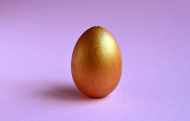 One easter golden egg on pastel background with space for text.Selective focus.	