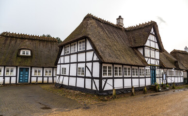 Fototapeta na wymiar Traditional old country houses with thatched straw roof on street in Denmark