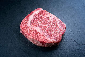 Raw dry aged wagyu cutlet steak cut offered as close-up on black background with copy space