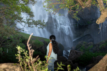 Girl standing next to a waterfall