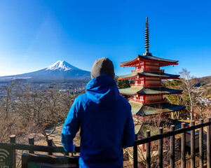 A man admiring Chureito Pagoda and view on Mt Fuji, Japan, captured on a clear, sunny day in...
