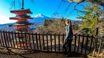 Girl admiring Chureito Pagoda and view on Mt Fuji, Japan, captured on a clear, sunny day in winter....