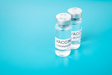 Covid-19 vaccine production, vaccination vials on blue medical background with copyspace