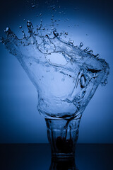 A glass of water with splash against white background