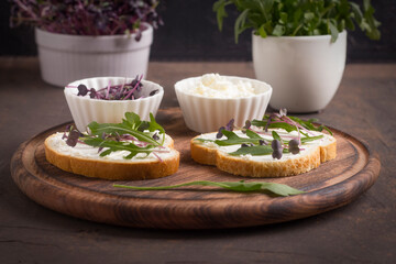 Two sandwiches with amaranth microgreens - purple leaves and stems and fresh rucola leaves. Vegan and healthy food concept.