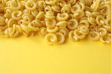 Button-shaped pasta on a yellow background. Concept - Italian cuisine.