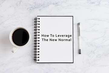Notebook on desk written how to leverage the new normal